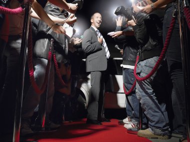 adam kırmızı halı paparazzi önünde