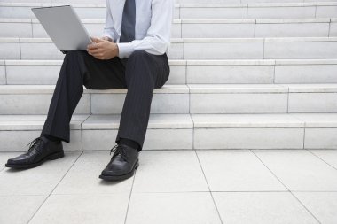 laptop adımları kullanarak iş adamı