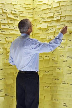 Businessman Looking at Sticky Notes clipart