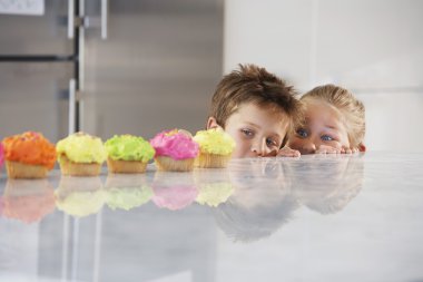 Kids Peeking at Cupcakes clipart