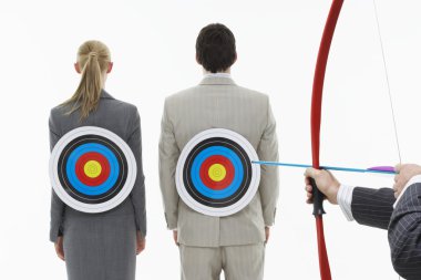 Two business people with targets on backs clipart