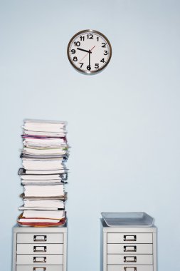 Office wall with clock stack of paperwork clipart