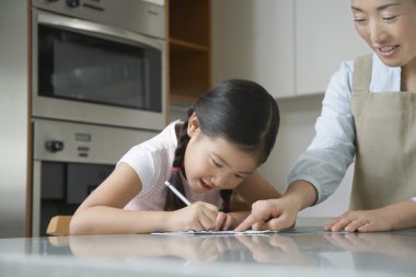 Mother with Daughter at kitchen counter clipart