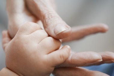 Bebek kadının elini tutuyor.