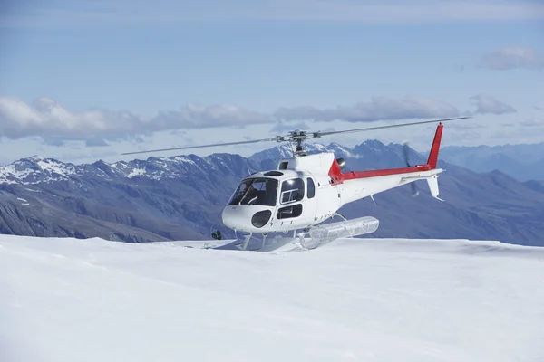 Helicóptero no topo da montanha nevado — Fotografia de Stock