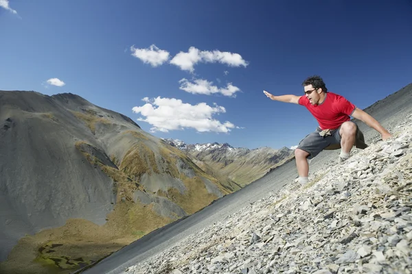 Hombre deslizándose por el campo de la pantalla en las montañas — Foto de Stock