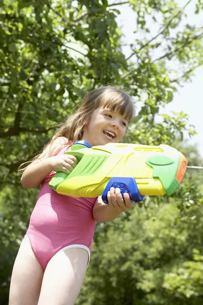 Girl shooting water pistol — Stock Photo, Image