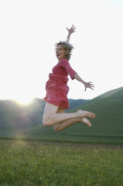 Femme sautant dans la prairie — Photo