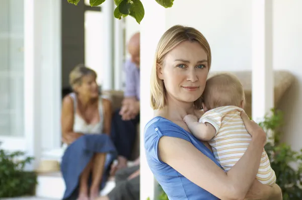Annesi holding bebek verandada — Stok fotoğraf