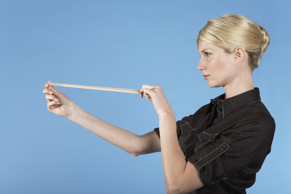 Businesswoman shooting rubber band