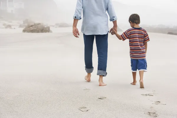 Vader en zoon hand in hand op strand — Stockfoto