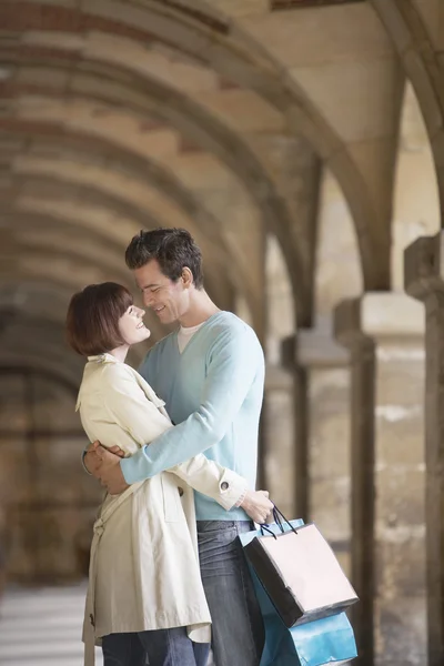 Couple with shopping bags embracing — Stock Photo, Image