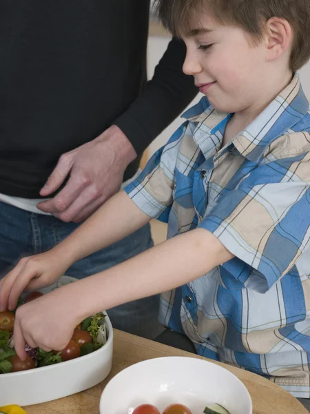 Vader en zoon voorbereiding salade — Stockfoto