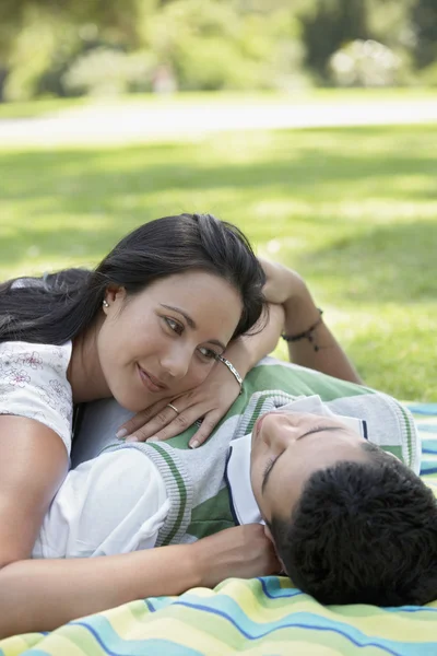 Couple lying down in park — Stock Photo, Image