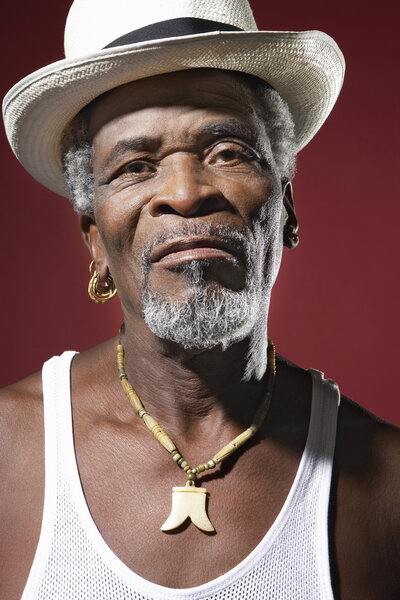 Африканский мужчина в фетровой шляпе и медальоне
