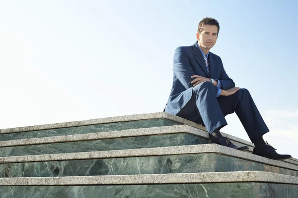 Muž sedí na mramorové schodiště — Stock fotografie