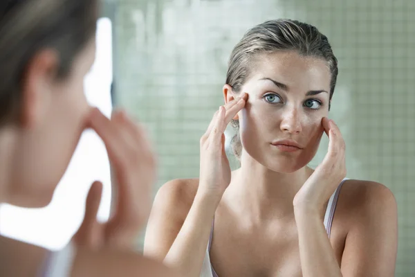 Mulher aplicando creme facial — Fotografia de Stock