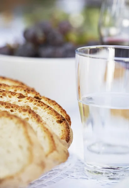 Pan rebanado y vaso de agua — Foto de Stock