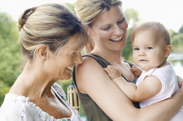Grandmother mother and daughter by lake