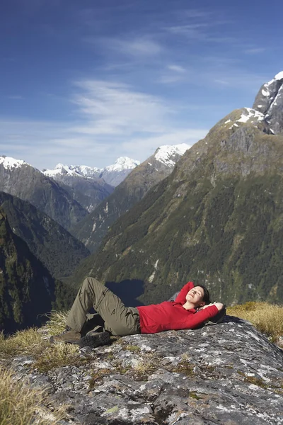 Woman laying on top of mountain — Stock Photo, Image