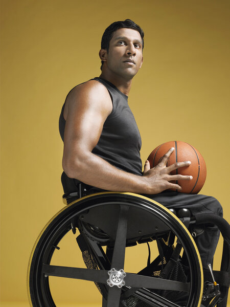 Paraplegic athlete holding basketball