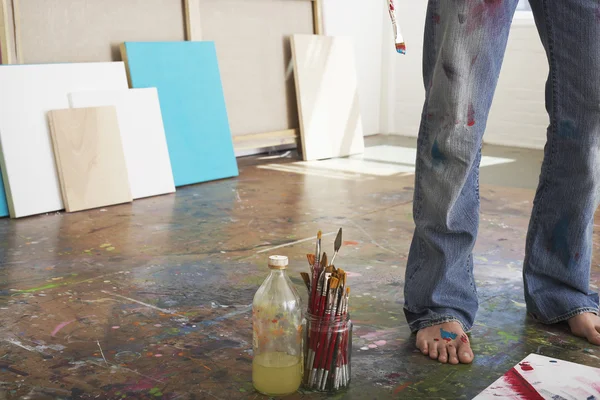 Artist standing by paint brushes — Stock Photo, Image