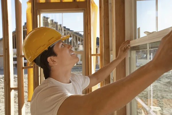 Travailleur de la construction travaillant sur fenêtre de bâtiment — Photo