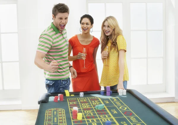 Man with friends celebrating gambling win — Stock Photo, Image