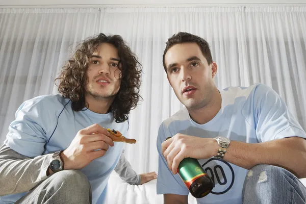 Men watching television with pizza and bee — Stock Photo, Image