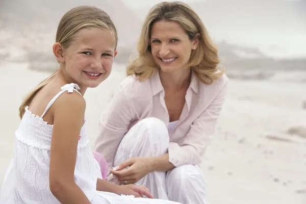 母亲和女儿坐在海滩上 — 图库照片
