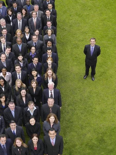 Hombre de negocios junto a un gran grupo de personas — Foto de Stock