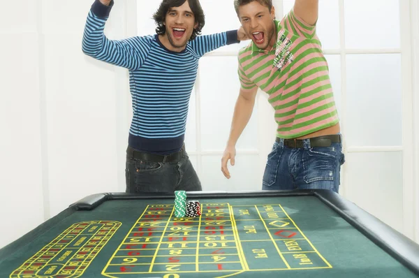 Uomini che festeggiano sul tavolo della roulette — Foto Stock