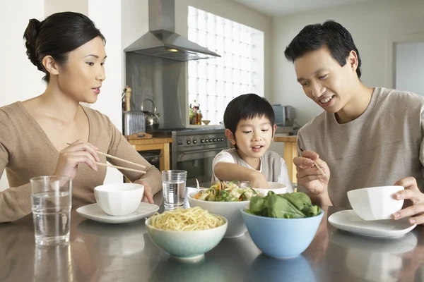 Parents watching son stick hand in bowl — Stock Photo, Image