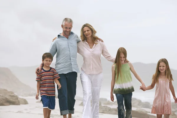 Familia con niños caminando en la playa —  Fotos de Stock