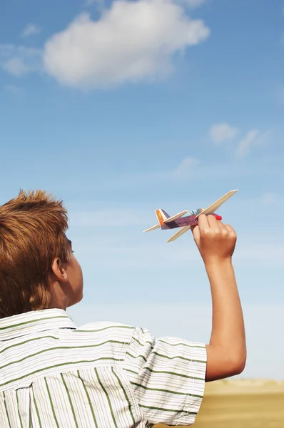 Junge fliegt Spielzeugflugzeug — Stockfoto