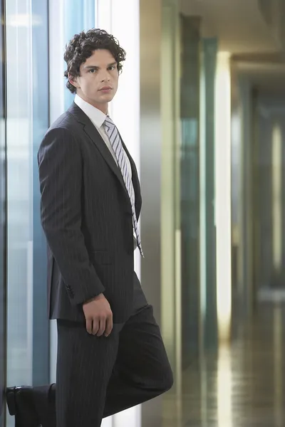 Biznesmen stojący w korytarzu biurowym — Zdjęcie stockowe