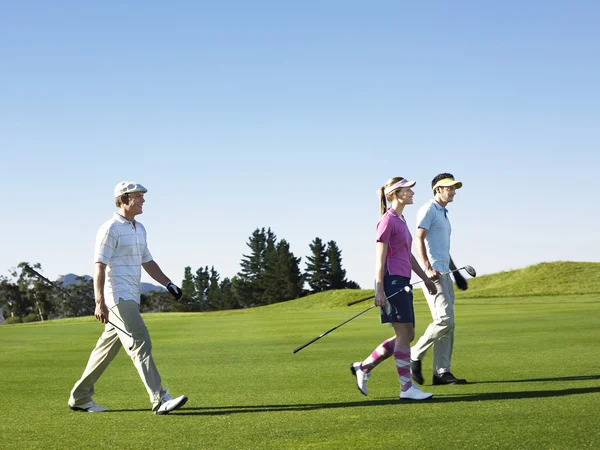Unga golfare gå på kurs — Stockfoto