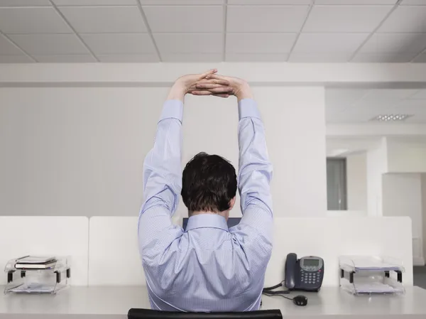 Büroangestellte dehnt sich am Schreibtisch — Stockfoto