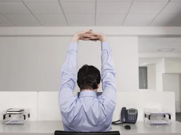 Trabalhador de escritório alongamento na mesa — Fotografia de Stock