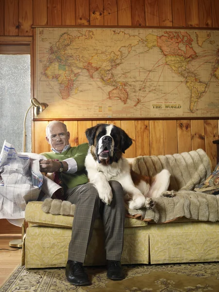 Senior man with newspaper and dog — Stock Photo, Image