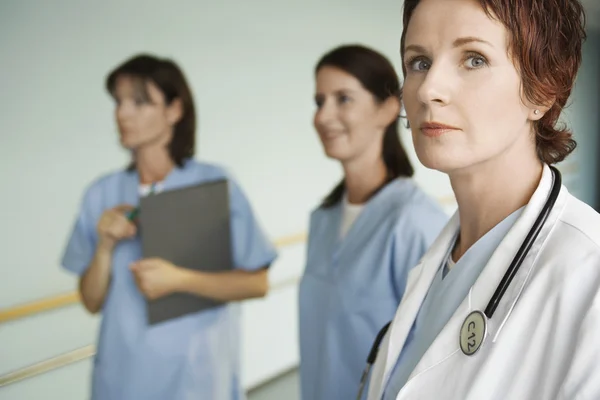 Ernsthafter Arzt mit Krankenschwestern im Krankenhaus — Stockfoto