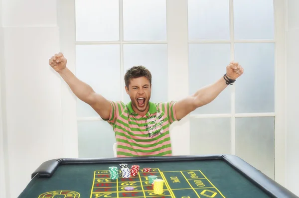 Man celebrating on roulette table — Stock Photo, Image