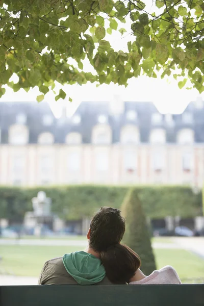 Woman leaning on man sitting on bench — Stock Photo, Image