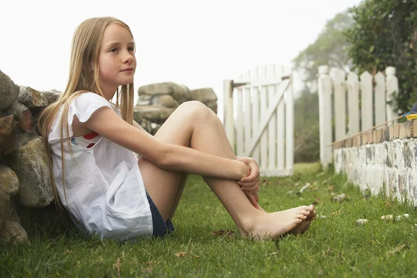 Meisje zit in tuin — Stockfoto