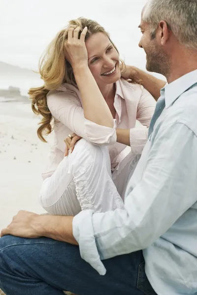 Pareja sentada en la playa — Foto de Stock