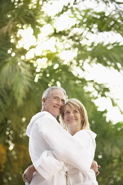 Pareja de pie junto a palmeras — Foto de Stock