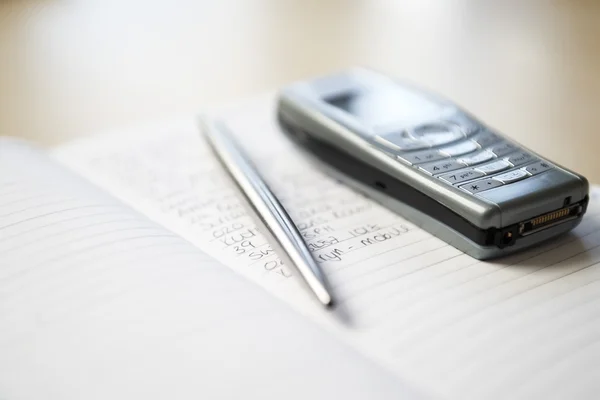 Mobiele telefoon en pen met laptop — Stockfoto