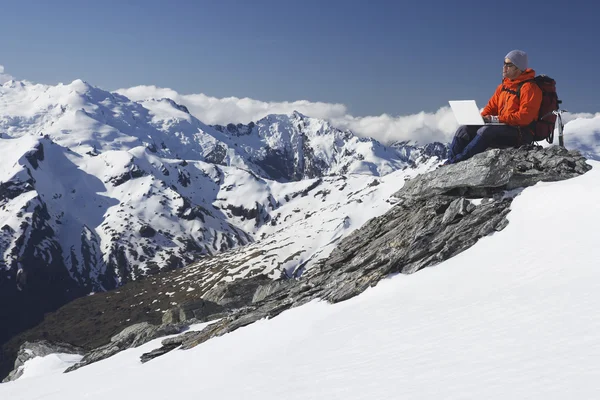 Scalatore di montagna con computer portatile — Foto Stock