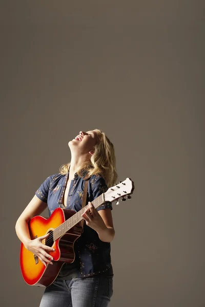 Γελώντας γυναίκα που παίζει κιθάρα — Φωτογραφία Αρχείου