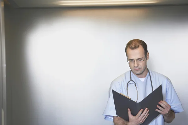 Läkare granska anteckningar i hiss — Stockfoto